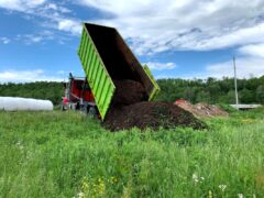 Truck dumping compost in field